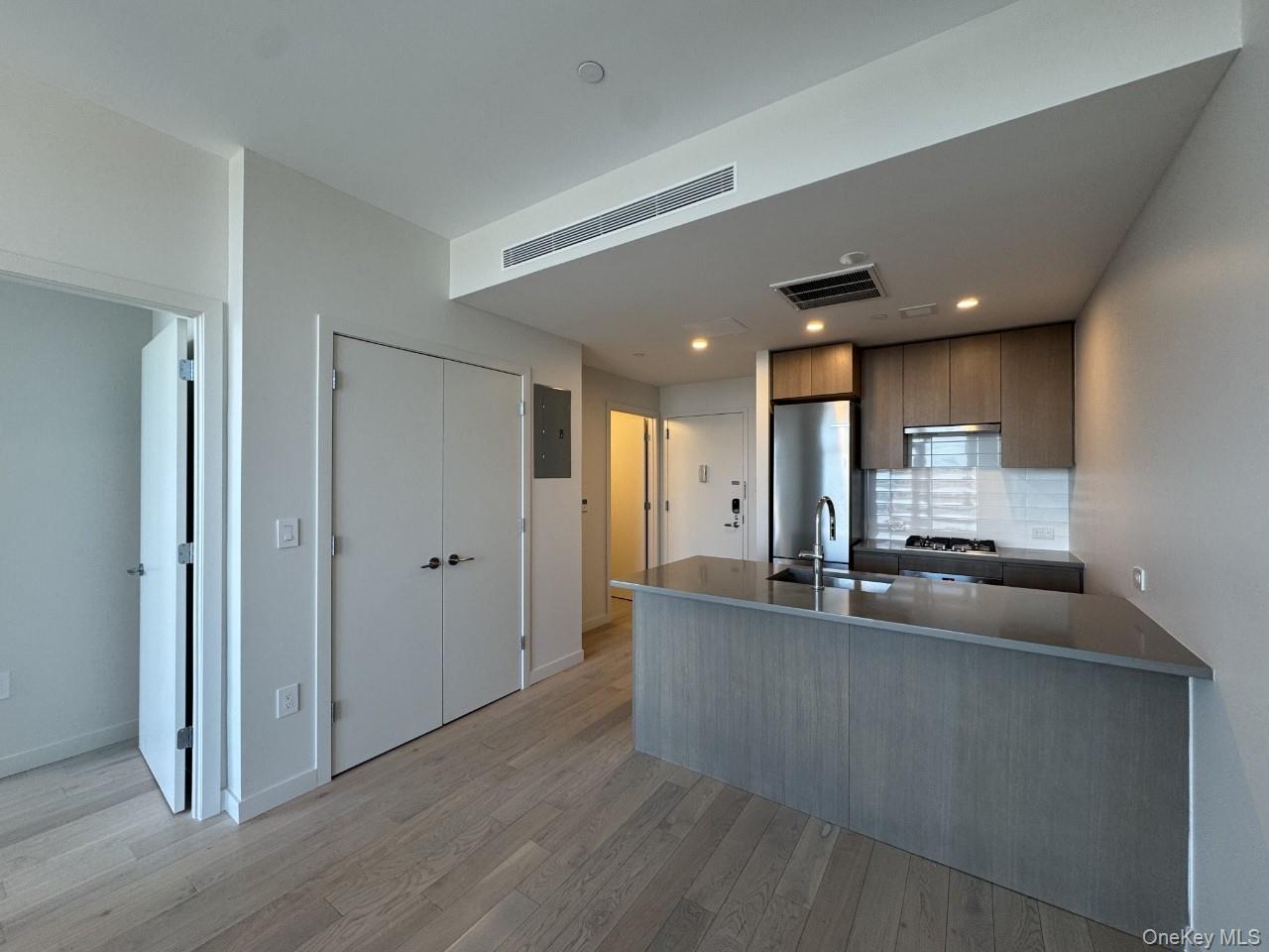 131-02 40th Road, Unit 9O Queens, NY 11354 - Photo 16 of 24 a kitchen with stainless steel appliances granite countertop a sink and a refrigerator