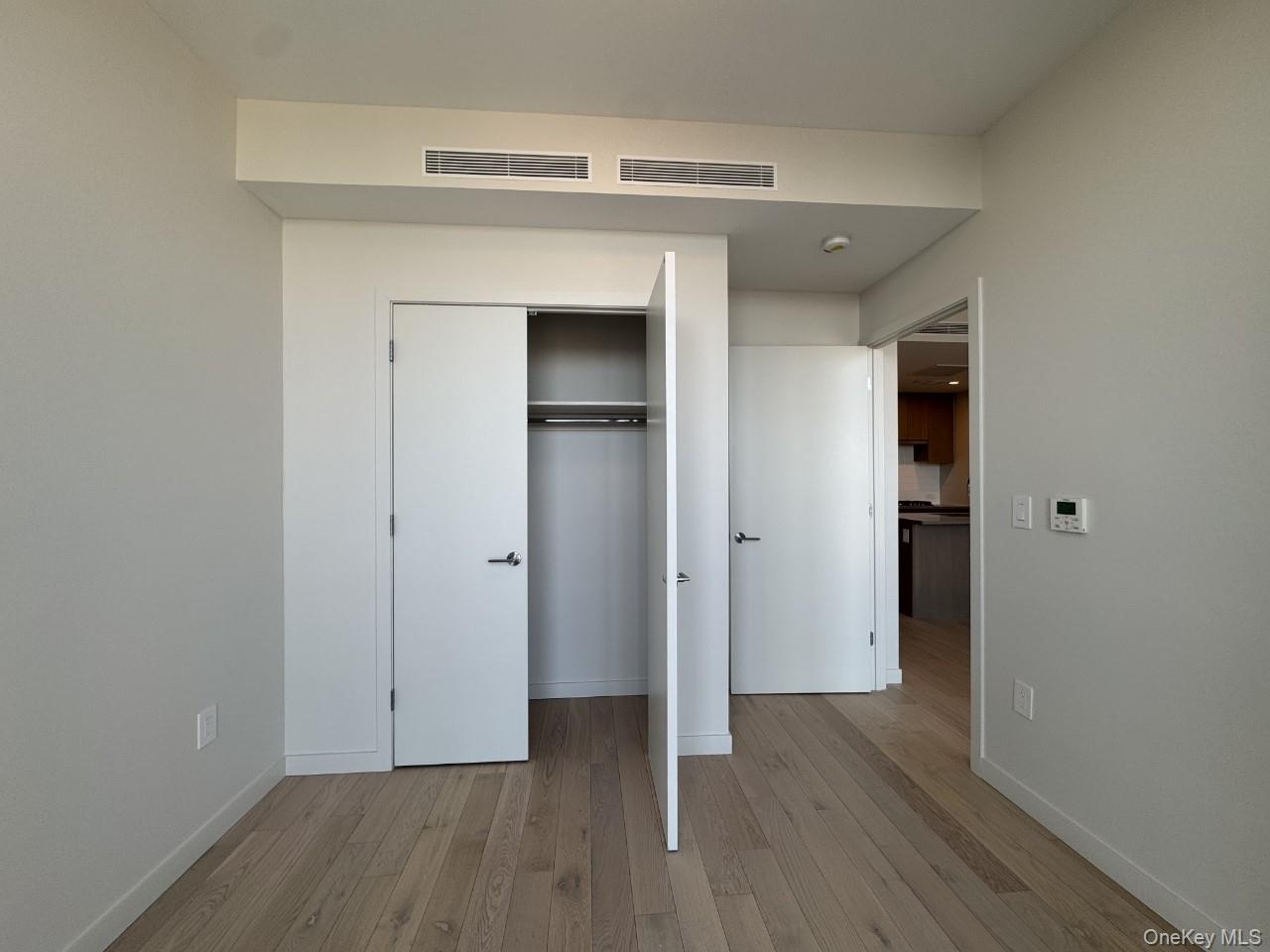 131-02 40th Road, Unit 9O Queens, NY 11354 - Photo 18 of 24 a view of an empty room with wooden floor