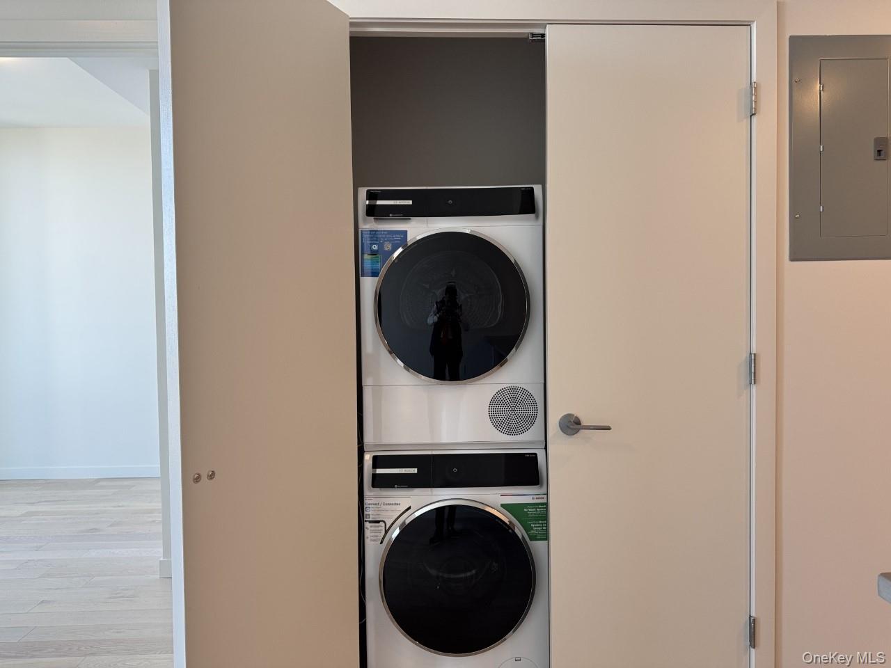 131-02 40th Road, Unit 9O Queens, NY 11354 - Photo 21 of 24 a view of a hallway with washer and dryer