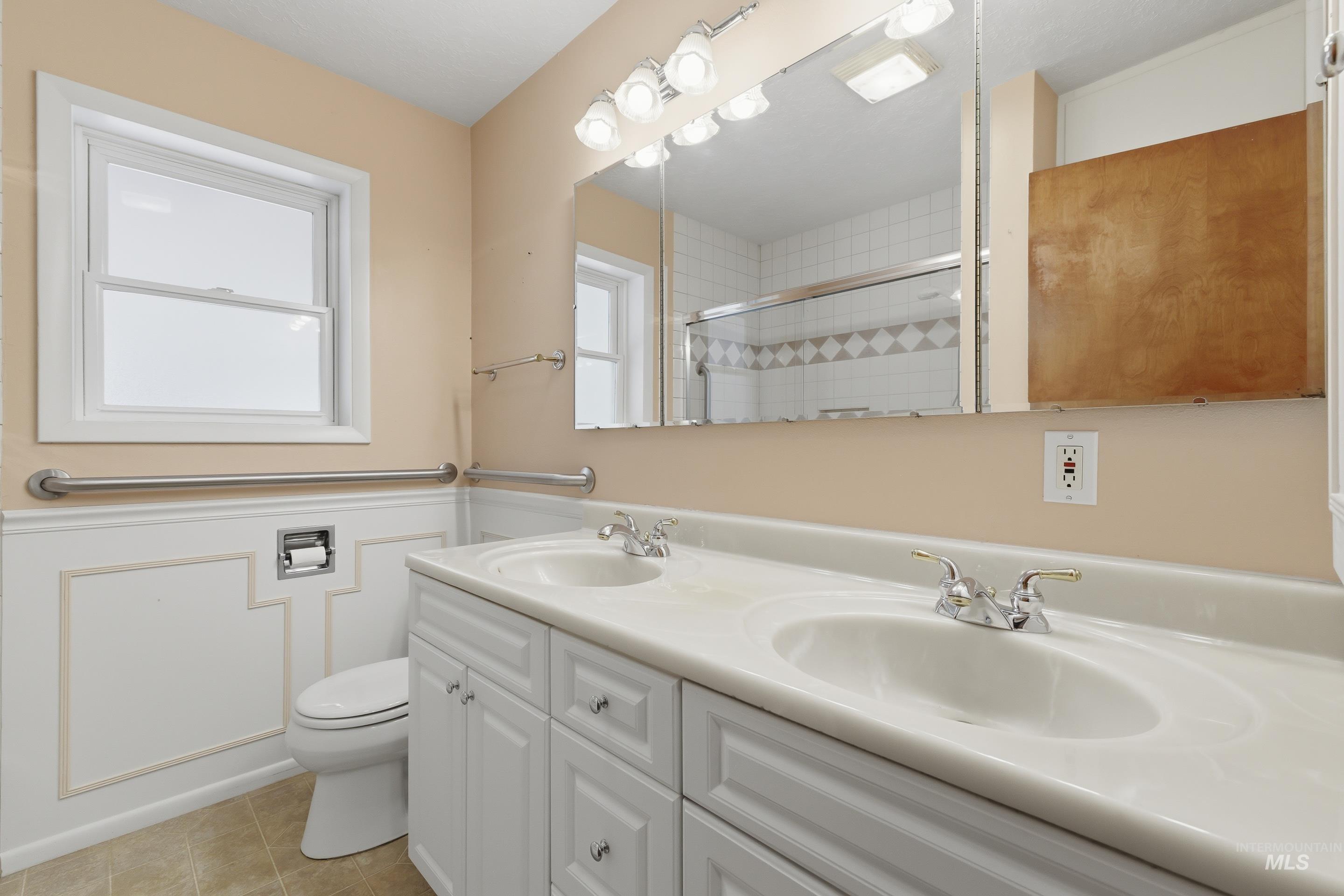 504 West Howe Street Boise, ID 83706 - Photo 26 of 47 Dual vanity with integrated sinks, white cabinetry, and polished chrome faucets