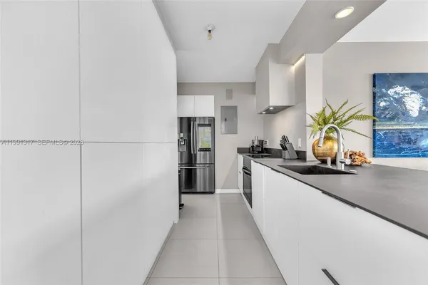 a kitchen with stainless steel appliances a sink a refrigerator a counter space and cabinets