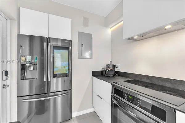 a kitchen with granite countertop a refrigerator and a sink