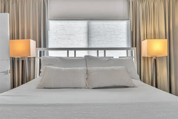 a bed sitting in a bedroom next to a window
