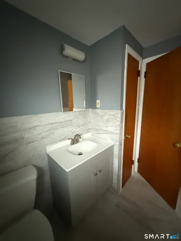 a bathroom with a sink toilet and mirror