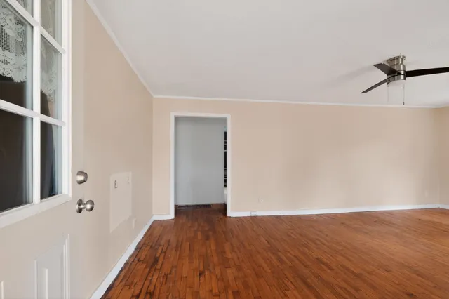 a view of a hallway with wooden floor and staircase