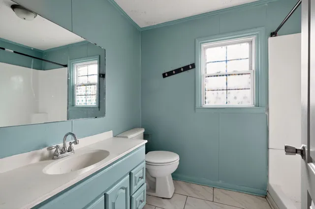 a bathroom with a toilet sink and mirror