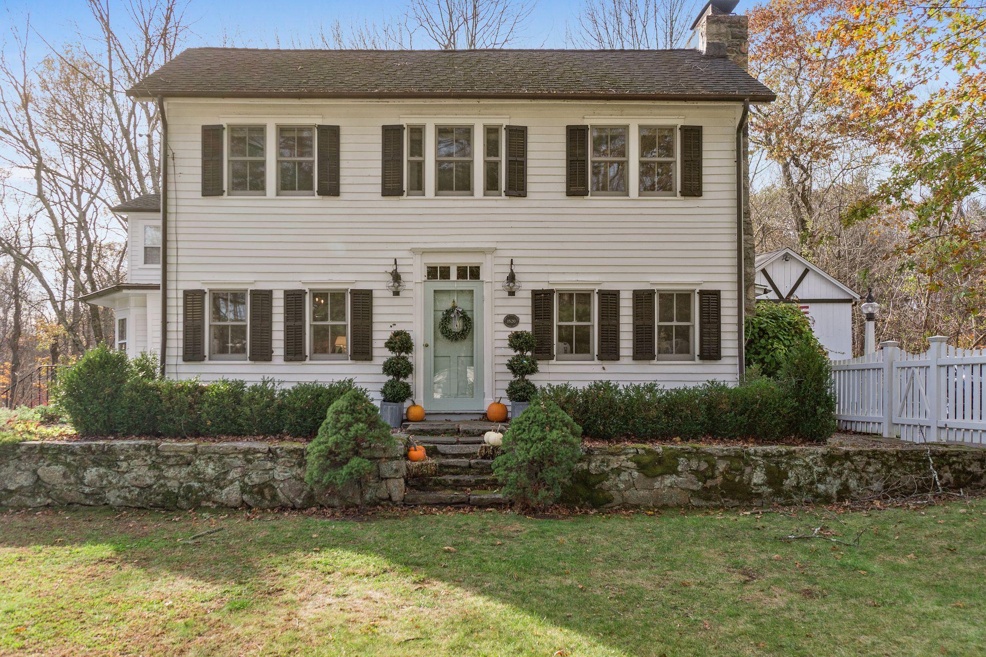 1122 Smith Ridge Road New Canaan, CT 06840 - Photo 1 of 25 a front view of a house with a yard and garage