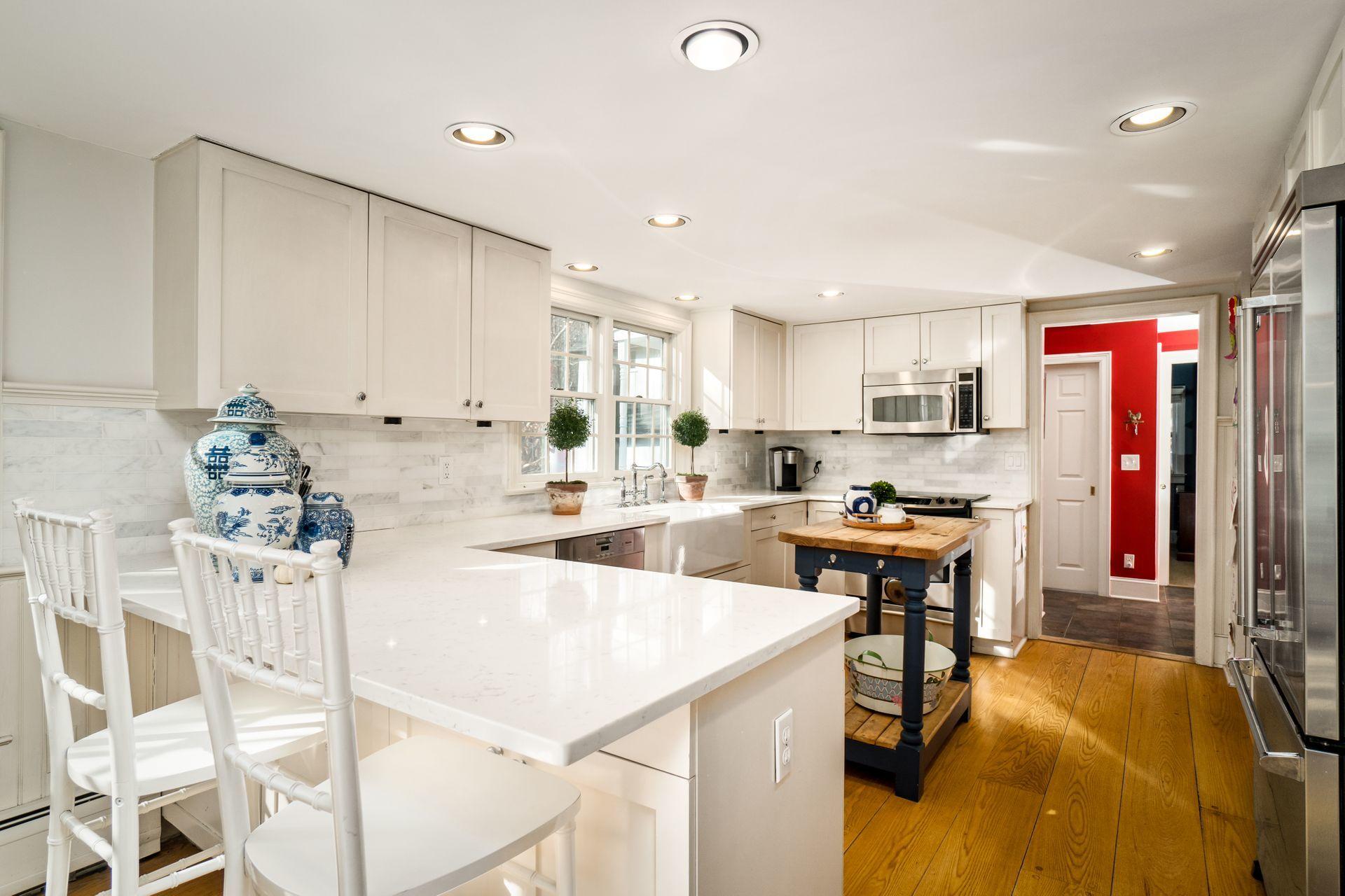1122 Smith Ridge Road New Canaan, CT 06840 - Photo 7 of 25 a kitchen with stainless steel appliances kitchen island granite countertop a table chairs sink and cabinets