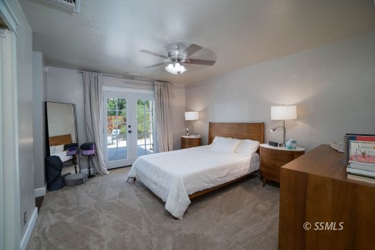 313 East Haloid Avenue Ridgecrest, CA 93555 - Photo 18 of 39 a spacious bedroom with a bed and a chandelier