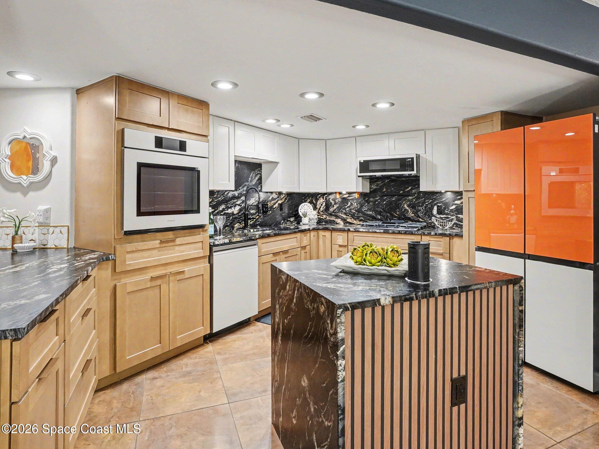 4045 Jake Avenue Cocoa, FL 32926 - Photo 13 of 35 a kitchen with stainless steel appliances granite countertop a sink a stove top oven a counter space and cabinets