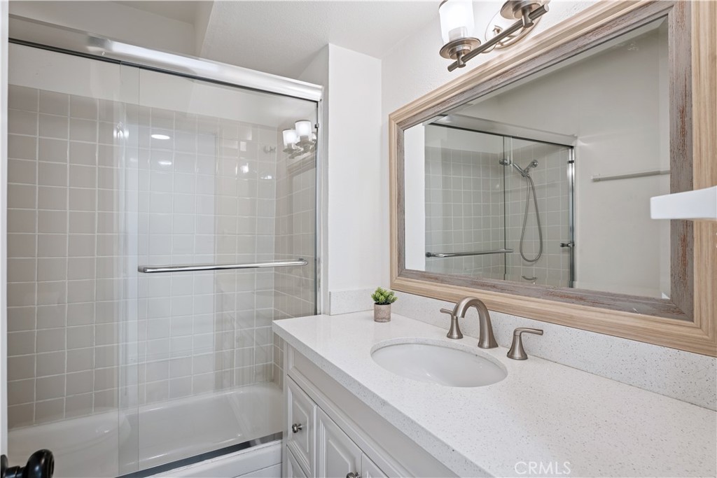 5330 Zelzah Avenue, Unit 7 Encino, CA 91316 - Photo 19 of 35 a bathroom with a granite countertop sink a mirror and a shower