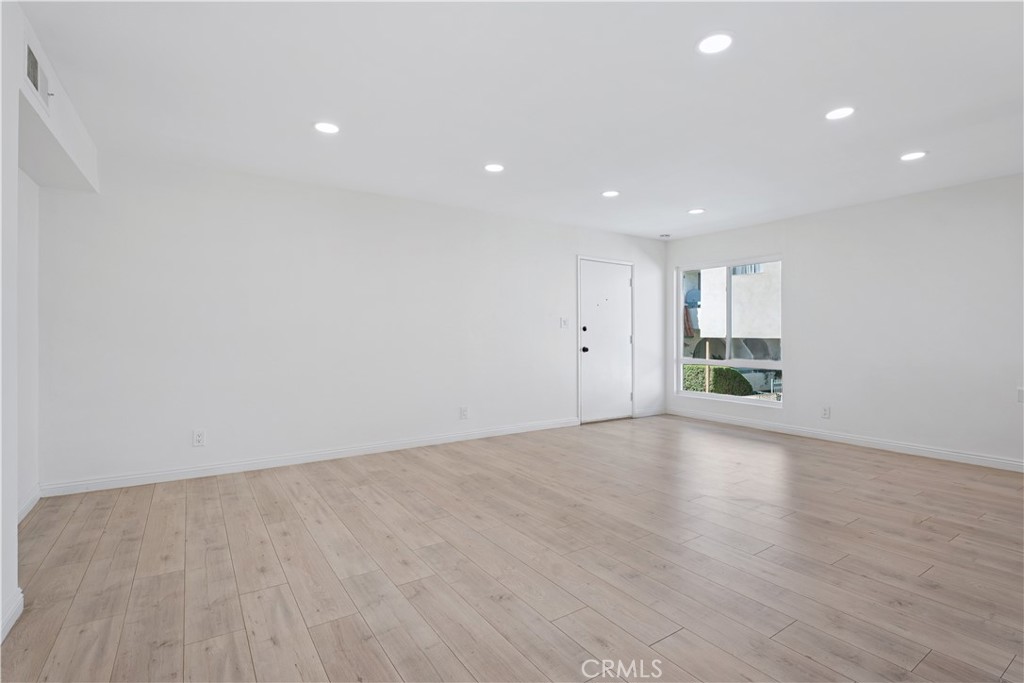 5330 Zelzah Avenue, Unit 7 Encino, CA 91316 - Photo 5 of 35 a view of an empty room with wooden floor and kitchen