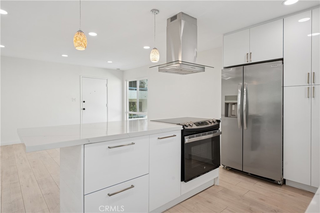 5330 Zelzah Avenue, Unit 7 Encino, CA 91316 - Photo 9 of 35 a kitchen with kitchen island stainless steel appliances a stove refrigerator and microwave