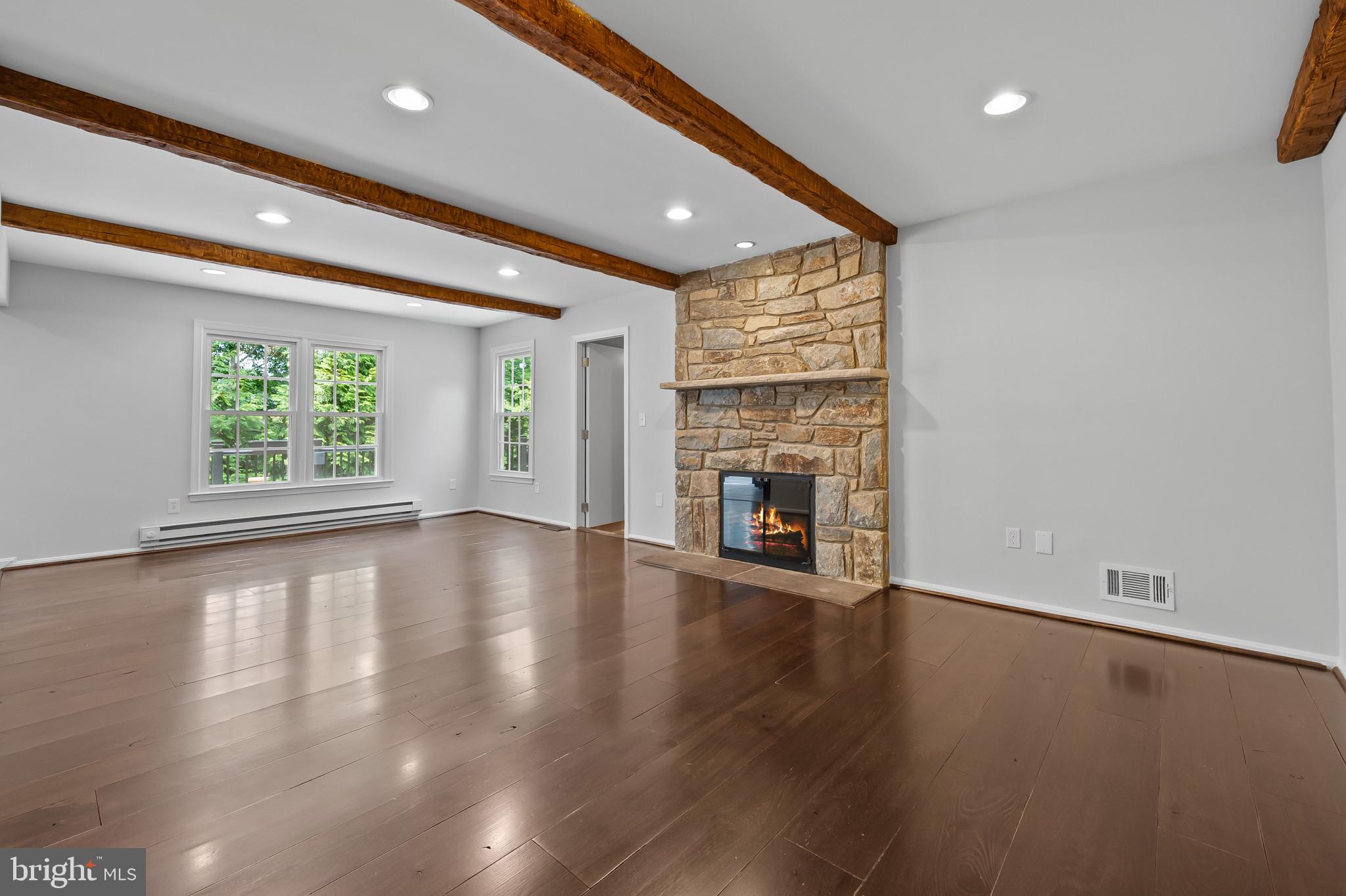 15016 Wellwood Road Silver Spring, MD 20905 - Photo 16 of 52 an empty room with wooden floor and a fireplace