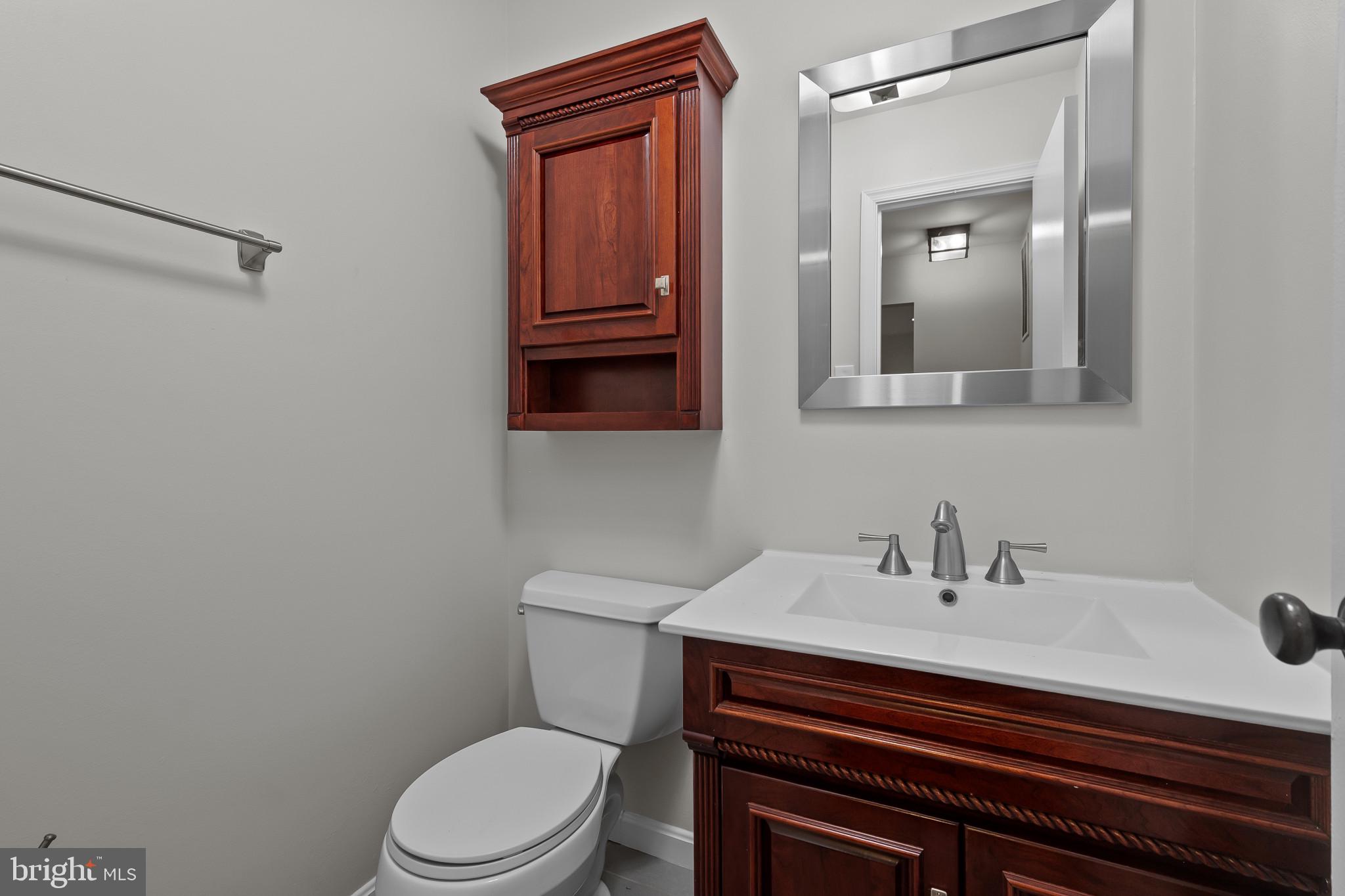 15016 Wellwood Road Silver Spring, MD 20905 - Photo 18 of 52 a bathroom with a sink a toilet and mirror