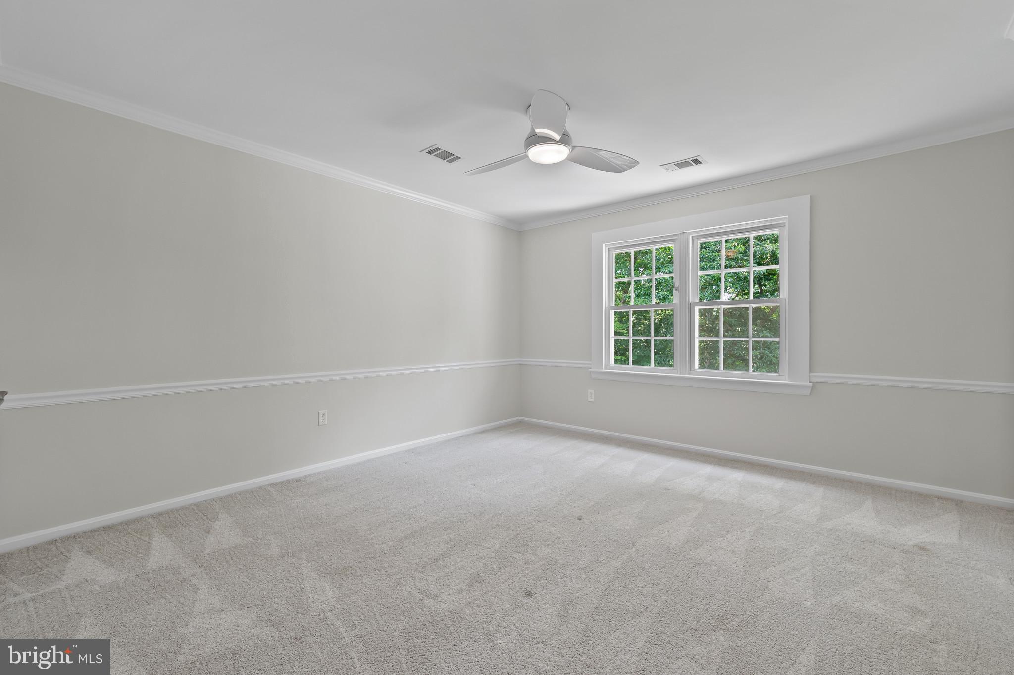15016 Wellwood Road Silver Spring, MD 20905 - Photo 26 of 52 an empty room with windows and chandelier fan