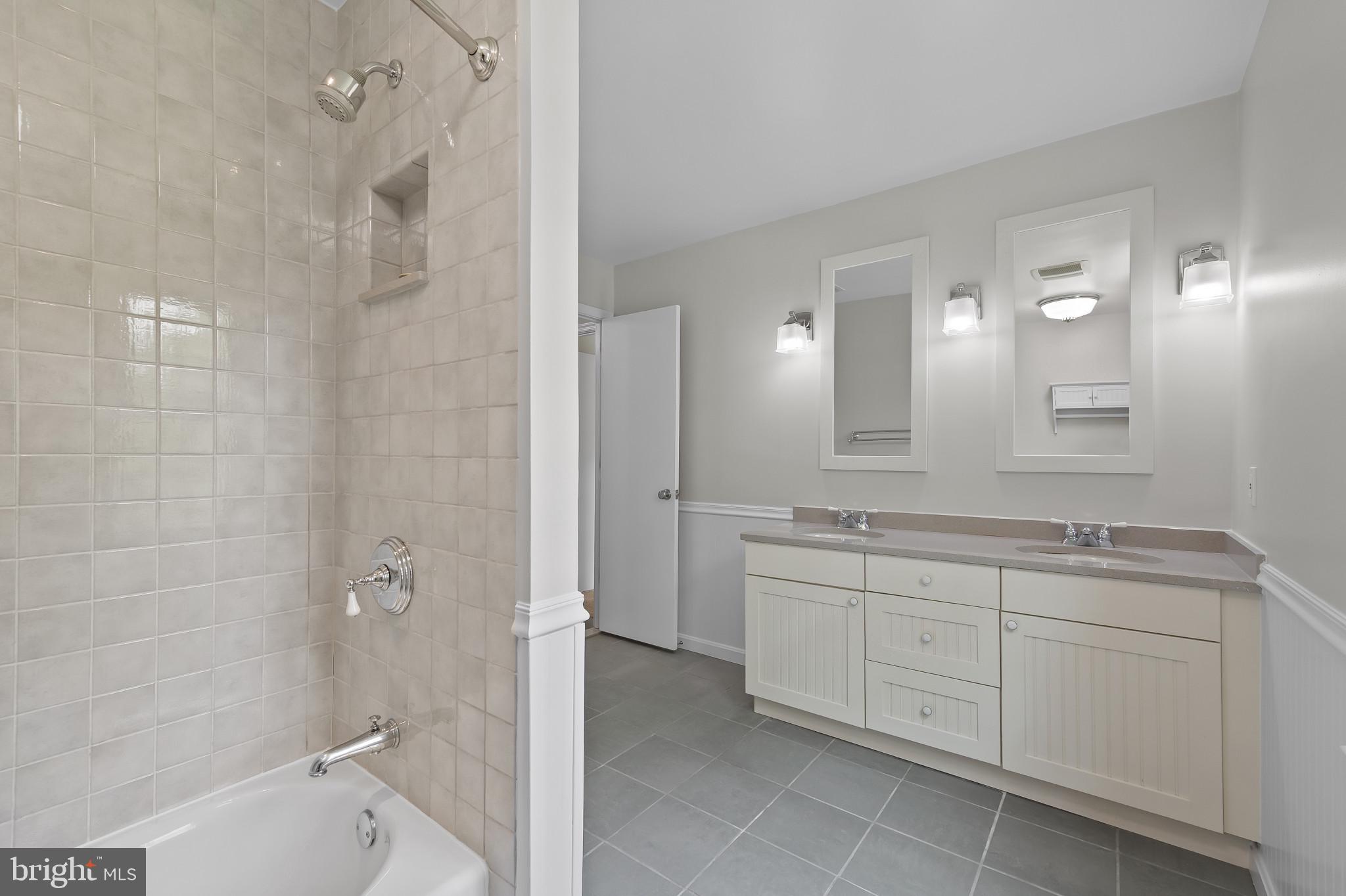 15016 Wellwood Road Silver Spring, MD 20905 - Photo 33 of 52 a spacious bathroom with a granite countertop sink a toilet mirror and shower