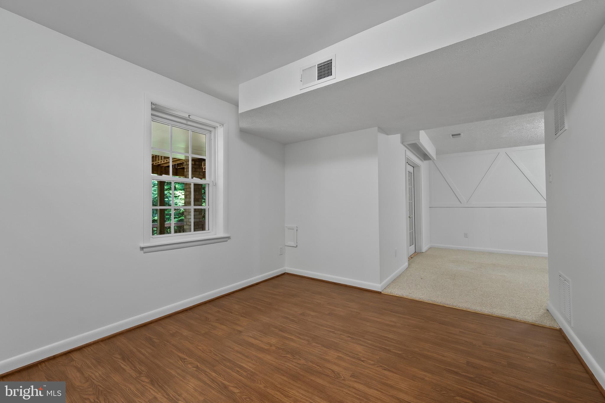 15016 Wellwood Road Silver Spring, MD 20905 - Photo 36 of 52 an empty room with wooden floor and windows