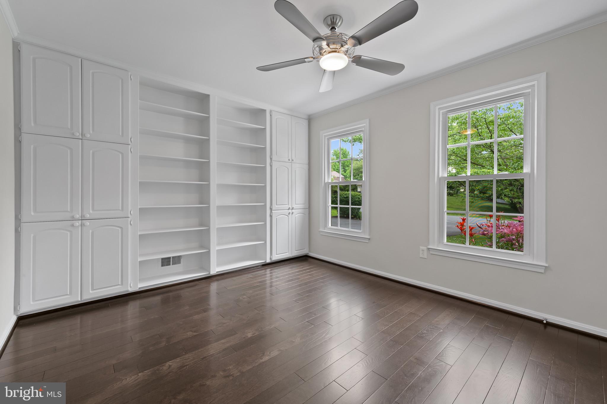 15016 Wellwood Road Silver Spring, MD 20905 - Photo 5 of 52 an empty room with wooden floor cabinet and windows