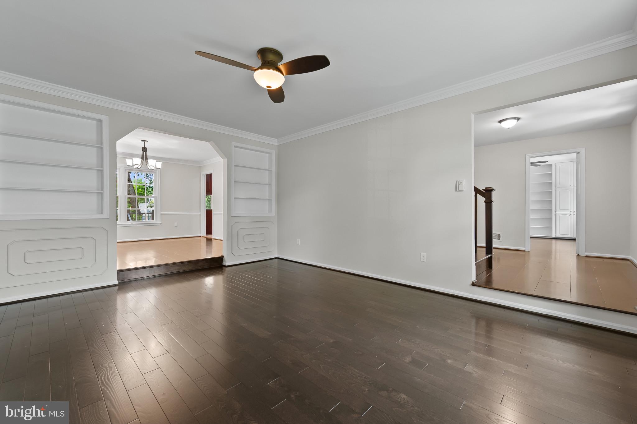 15016 Wellwood Road Silver Spring, MD 20905 - Photo 6 of 52 an empty room with wooden floor chandelier fan and windows