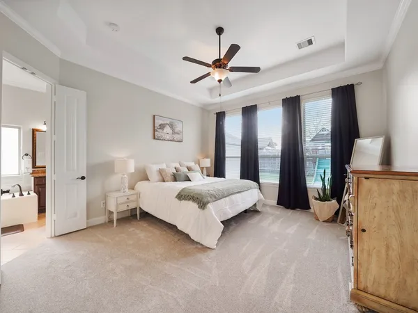 a spacious bedroom with a bed and a chandelier