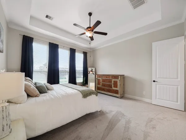 a bedroom with a bed dresser and a large window