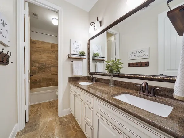a bathroom with a granite countertop sink a mirror and shower