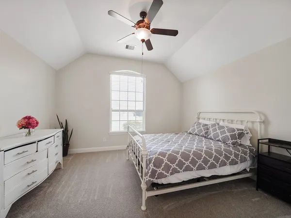 a bedroom with a bed and a chandelier fan