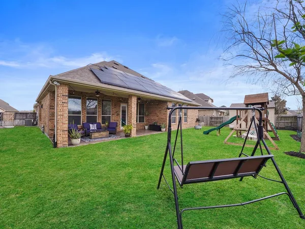 a view of a house with a yard potted plants and a large tree