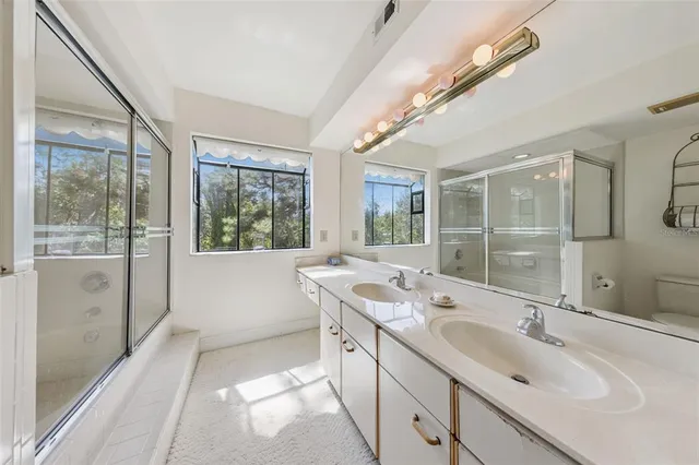 a bathroom with a double vanity sink and large mirror