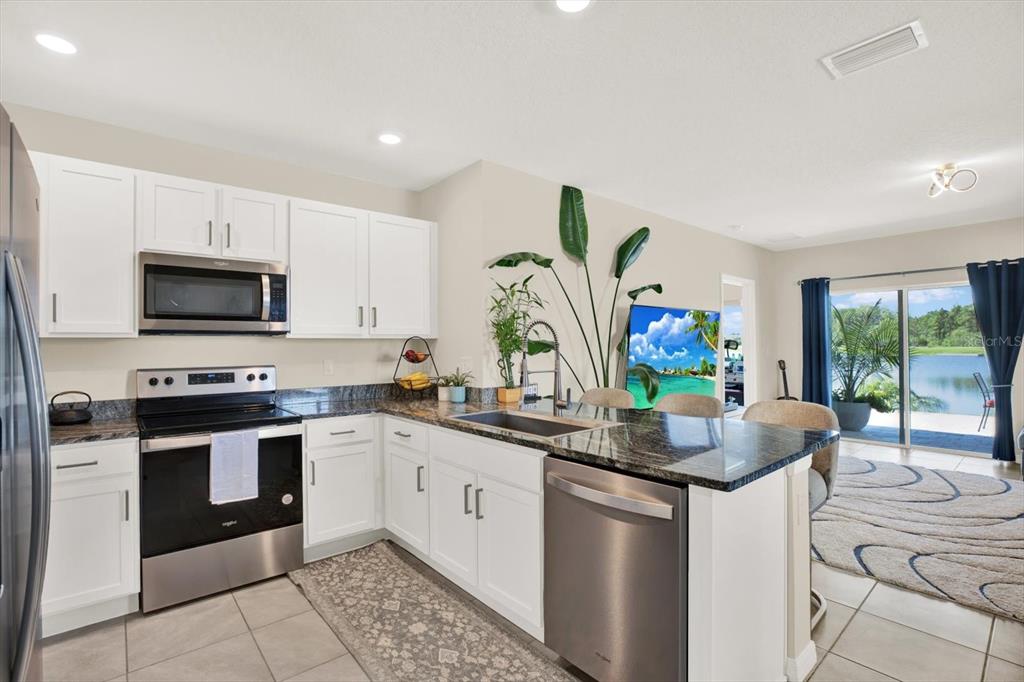 16034 Tuscany Hillside Road Odessa, FL 33556 - Photo 2 of 48 a kitchen with stainless steel appliances granite countertop a sink and a stove