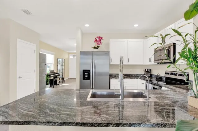 a kitchen with stainless steel appliances kitchen island granite countertop a refrigerator and stove