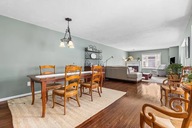 a dining room with furniture a chandelier and wooden floor