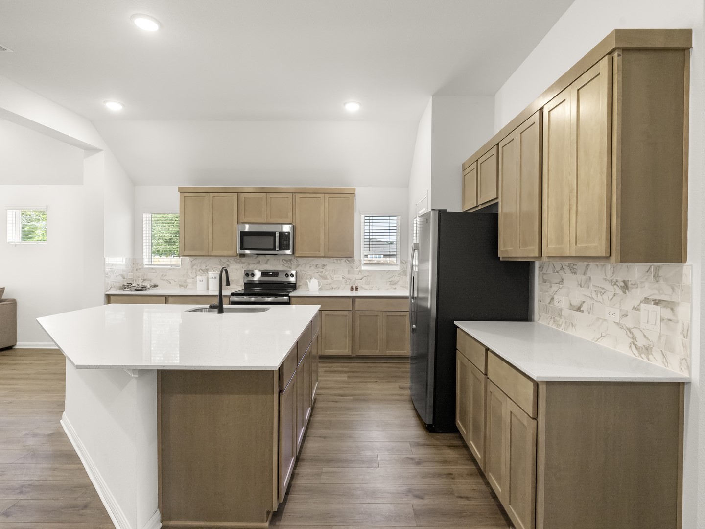 402 Judson Street Bertram, TX 78605 - Photo 6 of 27 a kitchen with kitchen island stainless steel appliances a sink stove refrigerator and cabinets
