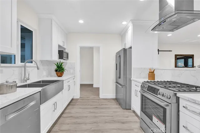 a kitchen with stainless steel appliances granite countertop a sink stove and refrigerator