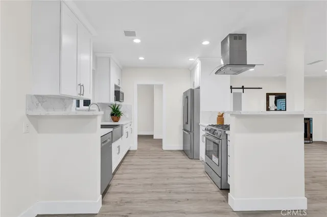 a kitchen with white cabinets and stainless steel appliances