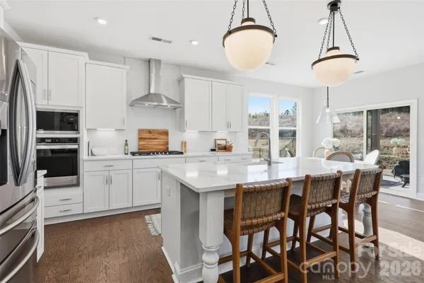 a kitchen with stainless steel appliances granite countertop a stove refrigerator and cabinets