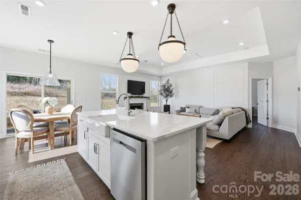 a kitchen with a sink a stove and chairs with wooden floor