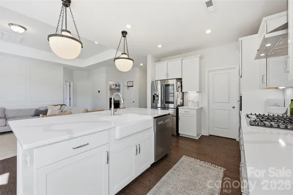 a large white kitchen with a refrigerator a sink and dishwasher