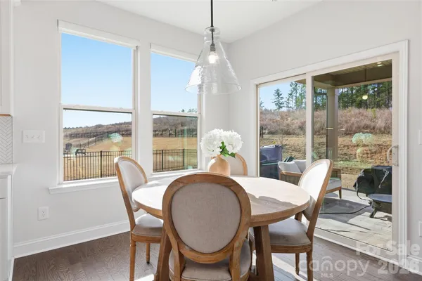 a dining room with furniture large windows and a chandelier