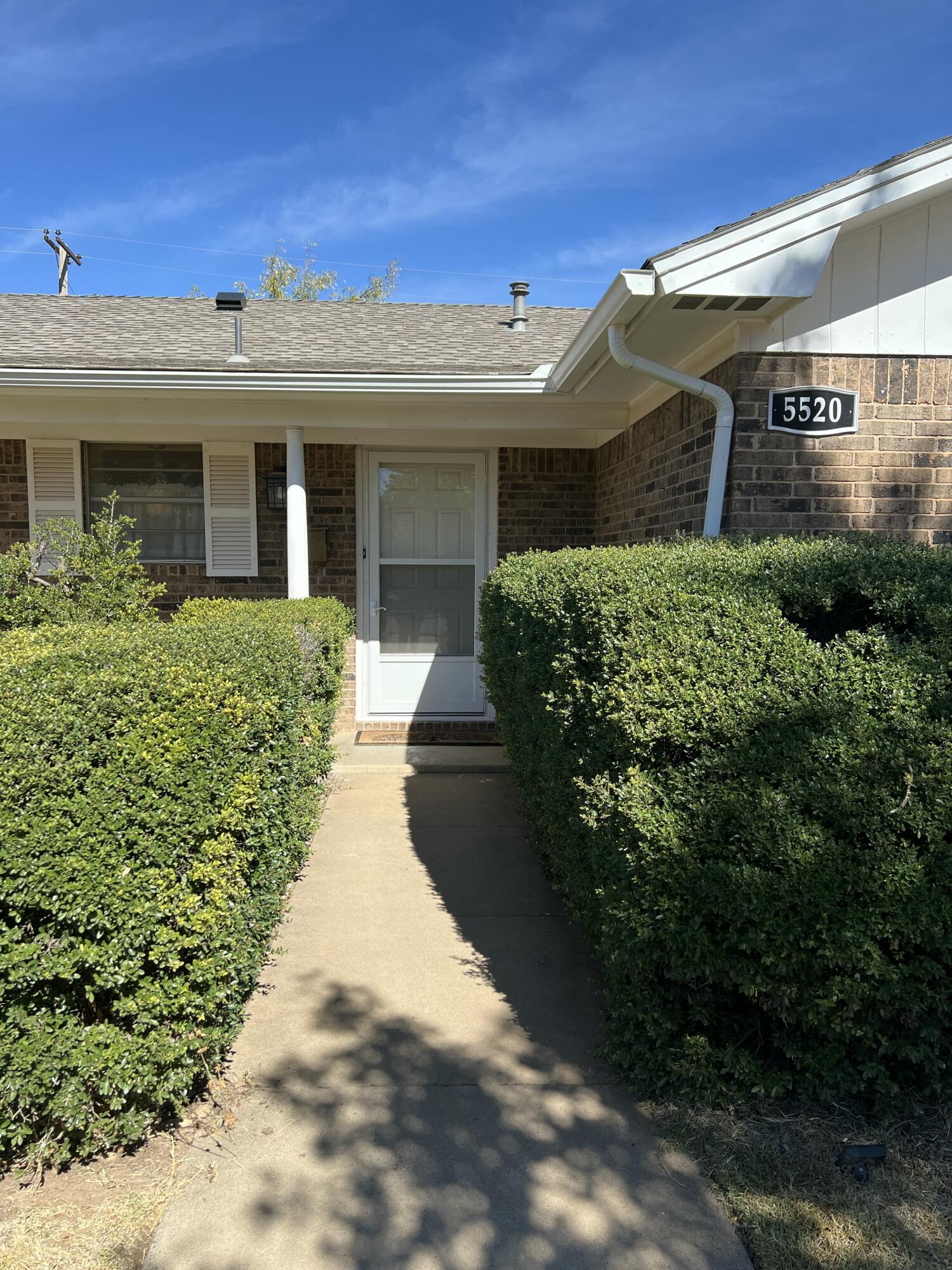 5520 36th Street Lubbock, TX 79407 - Photo 3 of 27 a view of a white house with a small yard and potted plants