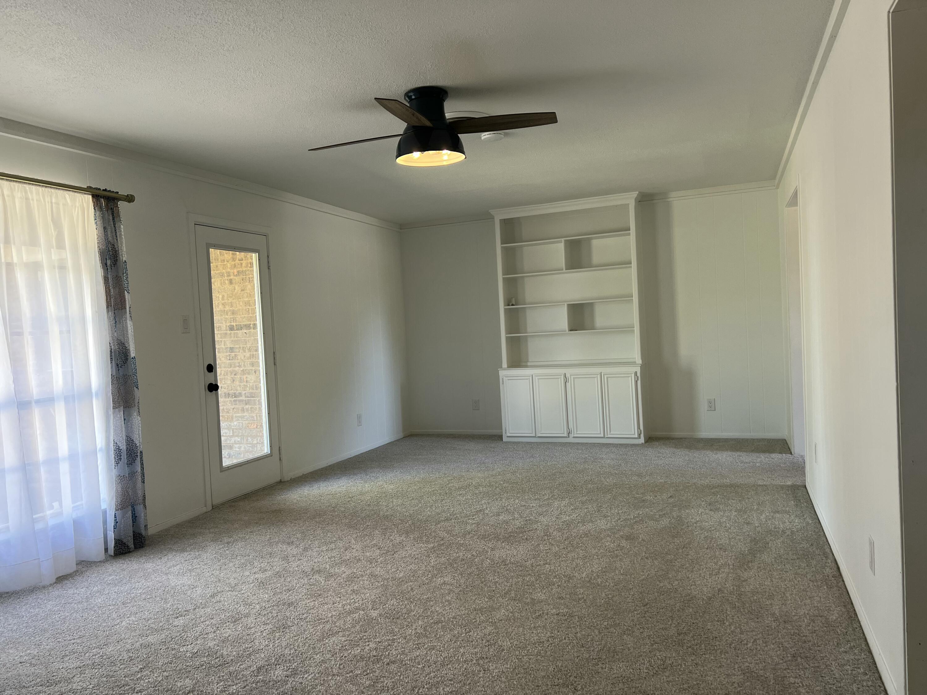 5520 36th Street Lubbock, TX 79407 - Photo 7 of 27 an empty room with windows and ceiling fan