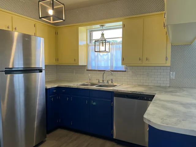 a kitchen with granite countertop cabinets stainless steel appliances and a counter space