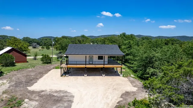 an aerial view of a house with a yard and lake view
