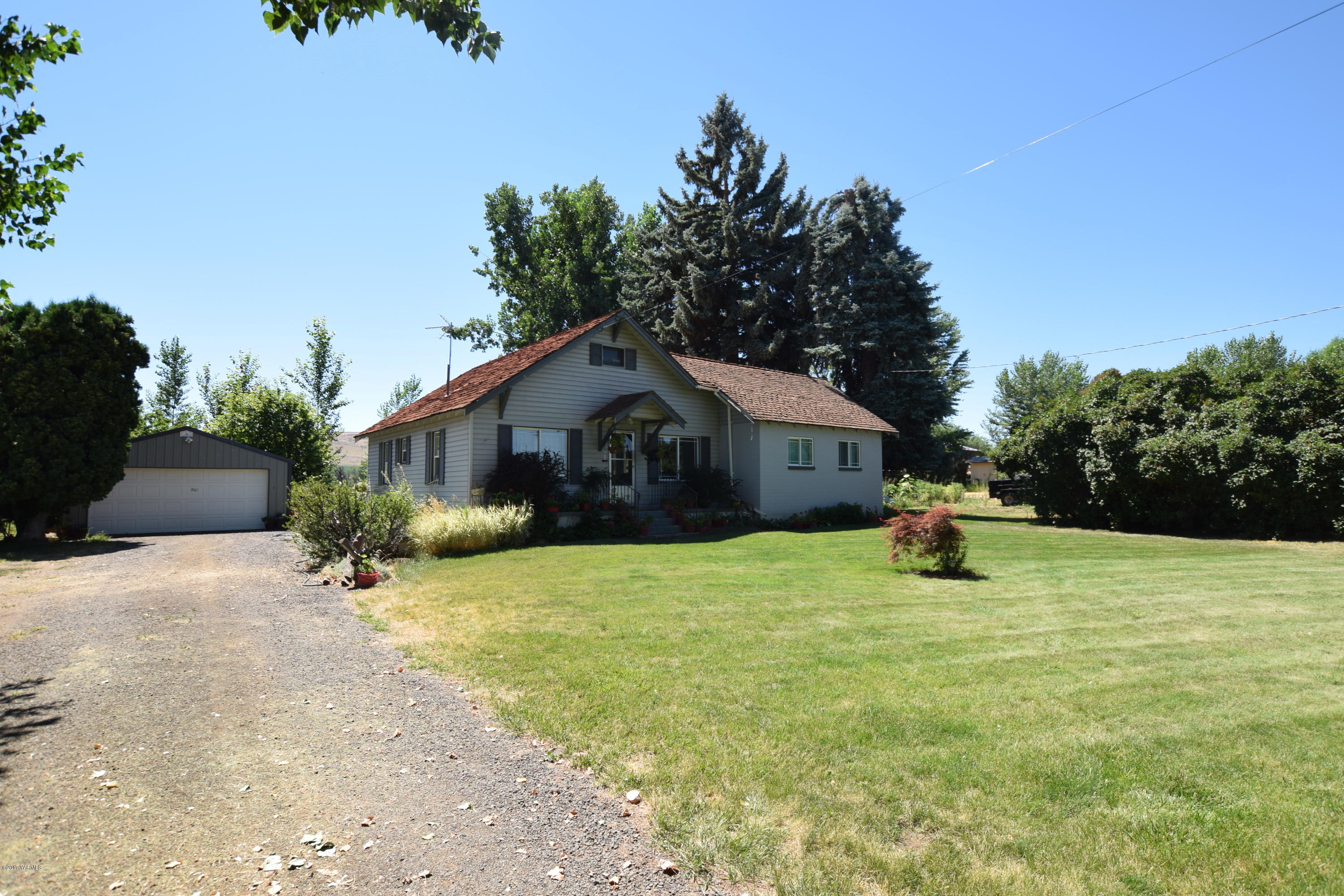 13760 Rutherford Road Yakima, WA 98903 - Photo 2 of 25 a house with tall trees in the background