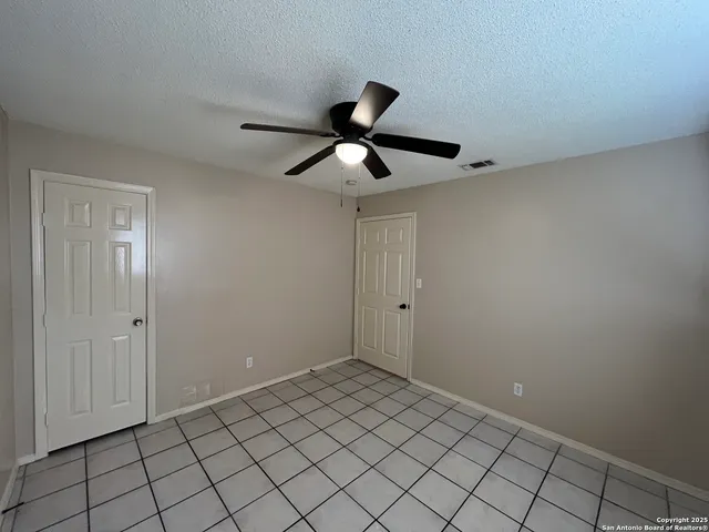 a view of a room with a ceiling fan and wooden floor