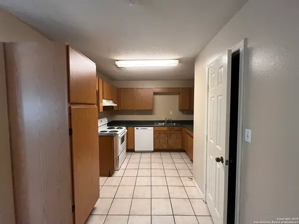 a kitchen with a refrigerator sink and cabinets