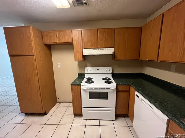 a kitchen with granite countertop white cabinets and sink