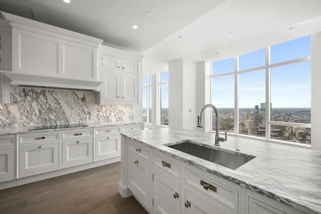 a kitchen with granite countertop a sink and white cabinets