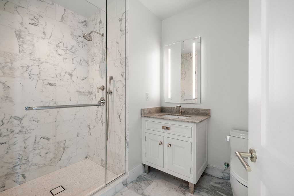 240 Devonshire Street, Unit PH 2C Boston, MA 02110 - Photo 13 of 42 a bathroom with a granite countertop sink a toilet and shower